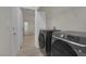 Laundry room area featuring gray washer and dryer units plus convenient shelving at 239 Highgate St, Henderson, NV 89074
