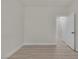 Bright, empty room featuring neutral walls and baseboards, white door, and modern wood-look floors at 239 Highgate St, Henderson, NV 89074