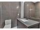 Modern bathroom with gray tile walls, sleek vanity and elegant fixtures at 2827 Richmar Ave, Henderson, NV 89074