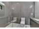 Modern bathroom with glass shower, gray tile walls, and sleek fixtures at 2827 Richmar Ave, Henderson, NV 89074