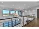 Hallway with steel cable railing and hardwood floors overlooking the first floor living area with views at 2827 Richmar Ave, Henderson, NV 89074