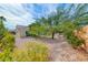Landscaped backyard with gravel, mature trees and privacy hedges at 3032 Stratmoor Hills Ave, Henderson, NV 89052