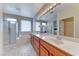 Bathroom featuring a double sink vanity, soaking tub, and a separate glass-enclosed shower at 3032 Stratmoor Hills Ave, Henderson, NV 89052