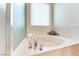 Corner soaking tub with chrome fixtures, a window, and marble surround at 3032 Stratmoor Hills Ave, Henderson, NV 89052
