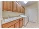 Well-lit laundry room featuring modern washer/dryer and ample cabinet space above the sink at 3032 Stratmoor Hills Ave, Henderson, NV 89052