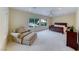 Spacious main bedroom with plush carpeting, natural light, and a cozy sitting area at 3032 Stratmoor Hills Ave, Henderson, NV 89052