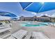 Outdoor swimming pool area with multiple lounge chairs and sun umbrellas at 3032 Stratmoor Hills Ave, Henderson, NV 89052