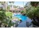 Sparkling community pool with swaying palm trees, lush vegetation, and lounge chairs for relaxation at 3145 E Flamingo Rd # 2119, Las Vegas, NV 89121