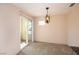 Bright dining area features a modern light fixture, neutral carpet, and glass patio doors at 3145 E Flamingo Rd # 2119, Las Vegas, NV 89121