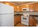 Well-lit kitchen featuring wooden cabinets, stone countertops and white appliances at 3145 E Flamingo Rd # 2119, Las Vegas, NV 89121