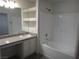 Bathroom features a shower over tub, vanity with granite countertop, and built-in storage shelves at 3507 Pointe Vedra Ct, Las Vegas, NV 89122