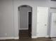 Hallway featuring an arched doorway and wood-look flooring that leads to other rooms in the house at 3507 Pointe Vedra Ct, Las Vegas, NV 89122