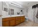 A bathroom with double sinks, wood cabinets, and a shower and tub combo at 3561 Yorba Linda Dr, Las Vegas, NV 89122