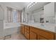 Well-lit main bathroom features a double sink vanity, soaking tub, and a separate glass shower at 3561 Yorba Linda Dr, Las Vegas, NV 89122