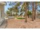 A simple backyard with minimal landscaping features desert ground cover and a few shady trees at 3710 E Oquendo Rd, Las Vegas, NV 89120