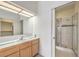 Bathroom featuring a single vanity, framed mirror, and glass-enclosed shower with tile accent at 3710 E Oquendo Rd, Las Vegas, NV 89120