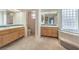 Bright bathroom featuring double vanities, a soaking tub with glass block windows, and tile accents at 3710 E Oquendo Rd, Las Vegas, NV 89120