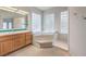 Bright bathroom featuring a soaking tub with glass block windows and a wood vanity at 3710 E Oquendo Rd, Las Vegas, NV 89120