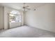 Bright and airy bedroom showcasing a large window with neighborhood views and a ceiling fan at 3710 E Oquendo Rd, Las Vegas, NV 89120