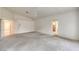 Spacious carpeted bedroom with white walls, ceiling fan, and access to an ensuite bathroom at 3710 E Oquendo Rd, Las Vegas, NV 89120