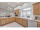 Sunlit kitchen features spacious countertops, wood cabinets, a large window, and view into breakfast nook at 3710 E Oquendo Rd, Las Vegas, NV 89120