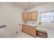 Functional laundry room with wood cabinets, a sink, and a tiled floor at 3710 E Oquendo Rd, Las Vegas, NV 89120