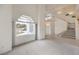 Open-concept living space with high ceilings, large window, and a staircase at 3710 E Oquendo Rd, Las Vegas, NV 89120