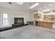 Open-concept living room featuring a fireplace, wet bar, carpeted floors, and natural light at 3710 E Oquendo Rd, Las Vegas, NV 89120