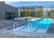 Bright pool with a clear blue water, multiple lounge chairs, cabana, and nearby steel and glass building at 3722 Las Vegas Blvd # 2204, Las Vegas, NV 89158