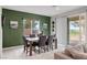 Inviting dining room features a stylish table set, green accent wall, and natural light from the sliding glass door at 4096 E Cactus Canyon Dr, Pahrump, NV 89061