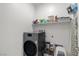 Functional laundry room with a modern washer and dryer set and shelving for supplies at 4096 E Cactus Canyon Dr, Pahrump, NV 89061