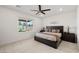 Serene bedroom featuring plush carpet, a ceiling fan, and a large window overlooking the backyard at 4096 E Cactus Canyon Dr, Pahrump, NV 89061