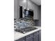 Close-up of a modern kitchen featuring stainless steel appliances, a stylish backsplash, and sleek gray cabinets at 4105 Falcons Flight Ave, North Las Vegas, NV 89084