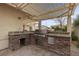 Delightful outdoor kitchen features a built-in grill, stainless steel appliances and bar seating at 4105 Falcons Flight Ave, North Las Vegas, NV 89084