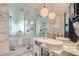 Modern bathroom with marble tile, dual sinks, and a glass-enclosed shower at 4381 W Flamingo Rd # 2608, Las Vegas, NV 89103