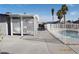 Backyard pool area featuring a covered patio, white fencing and mature palm trees under a bright blue sky at 4417 Rita Dr, Las Vegas, NV 89121