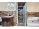 Bathroom featuring tiled walls, shower with shelving, and a vanity with dark wood cabinetry at 442 Republic St, Henderson, NV 89015