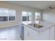 Bright kitchen island with stainless steel dishwasher, granite counters, sink, and sliding door access at 5204 Sunstone Mesa Dr, Las Vegas, NV 89166