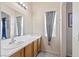 Bathroom showcasing a modern single sink vanity with a large mirror and window at 5908 High Steed St # 102, Henderson, NV 89011