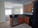 Modern kitchen with stainless steel sink and black appliances overlooks the living area at 6143 Majestic Wind Ave, Las Vegas, NV 89122