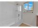Bright bathroom features a tub with glass doors and a window for natural light at 6325 Carmel Creek Ave, Las Vegas, NV 89139