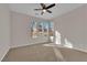 Sunlit bedroom with neutral carpet, ceiling fan, and three large windows at 6325 Carmel Creek Ave, Las Vegas, NV 89139