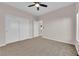 Spacious bedroom with neutral carpet, ceiling fan, and closet with sliding doors at 6325 Carmel Creek Ave, Las Vegas, NV 89139