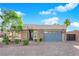Charming single-story home featuring stone accents, manicured landscaping, and a blue garage door at 6325 Carmel Creek Ave, Las Vegas, NV 89139