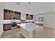 Modern kitchen featuring stainless steel appliances, a central island, and dark wood cabinets at 6325 Carmel Creek Ave, Las Vegas, NV 89139