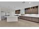 Well-lit kitchen features a large center island, stainless steel appliances, dark wood cabinets, and tile flooring at 6325 Carmel Creek Ave, Las Vegas, NV 89139