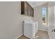 Well-equipped laundry room with overhead cabinets and a window for natural light at 6325 Carmel Creek Ave, Las Vegas, NV 89139
