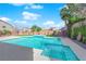 Backyard with a blue in-ground pool and a spa surrounded by lush landscaping and tall privacy walls at 6325 Carmel Creek Ave, Las Vegas, NV 89139