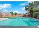 A beautiful in-ground pool with waterfall feature and palm trees in the backyard at 6325 Carmel Creek Ave, Las Vegas, NV 89139