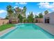 An in-ground backyard pool with waterfall feature is surrounded by lush landscaping at 6325 Carmel Creek Ave, Las Vegas, NV 89139